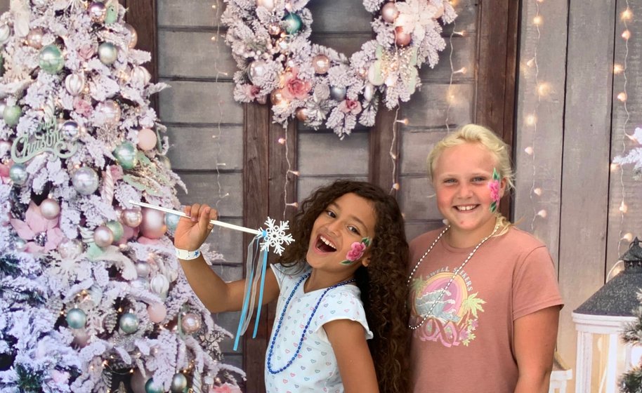 Couple holding props and smiling in booth