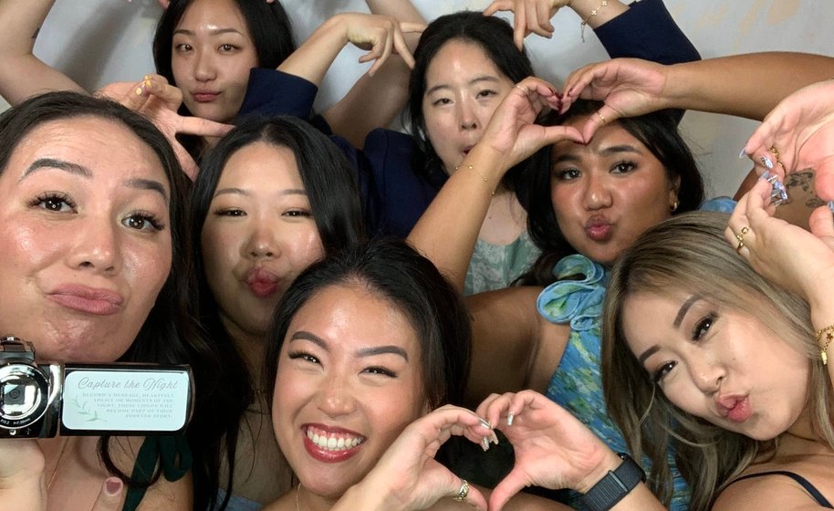 Party group striking playful poses in booth
