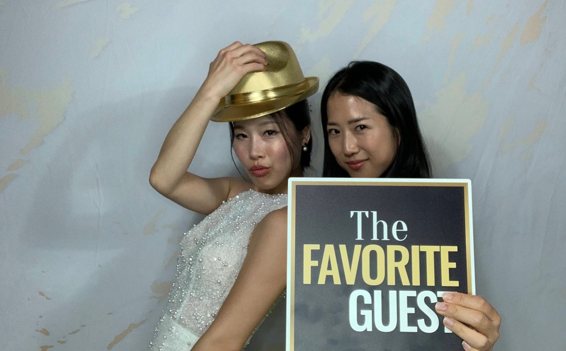 Party crowd posing under twinkle lights in booth