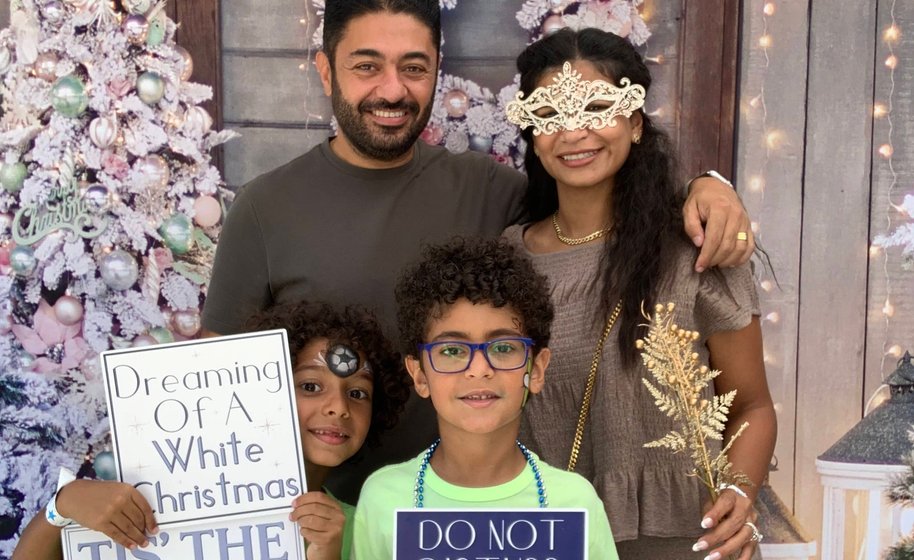 Guests holding drinks and smiling in photo booth